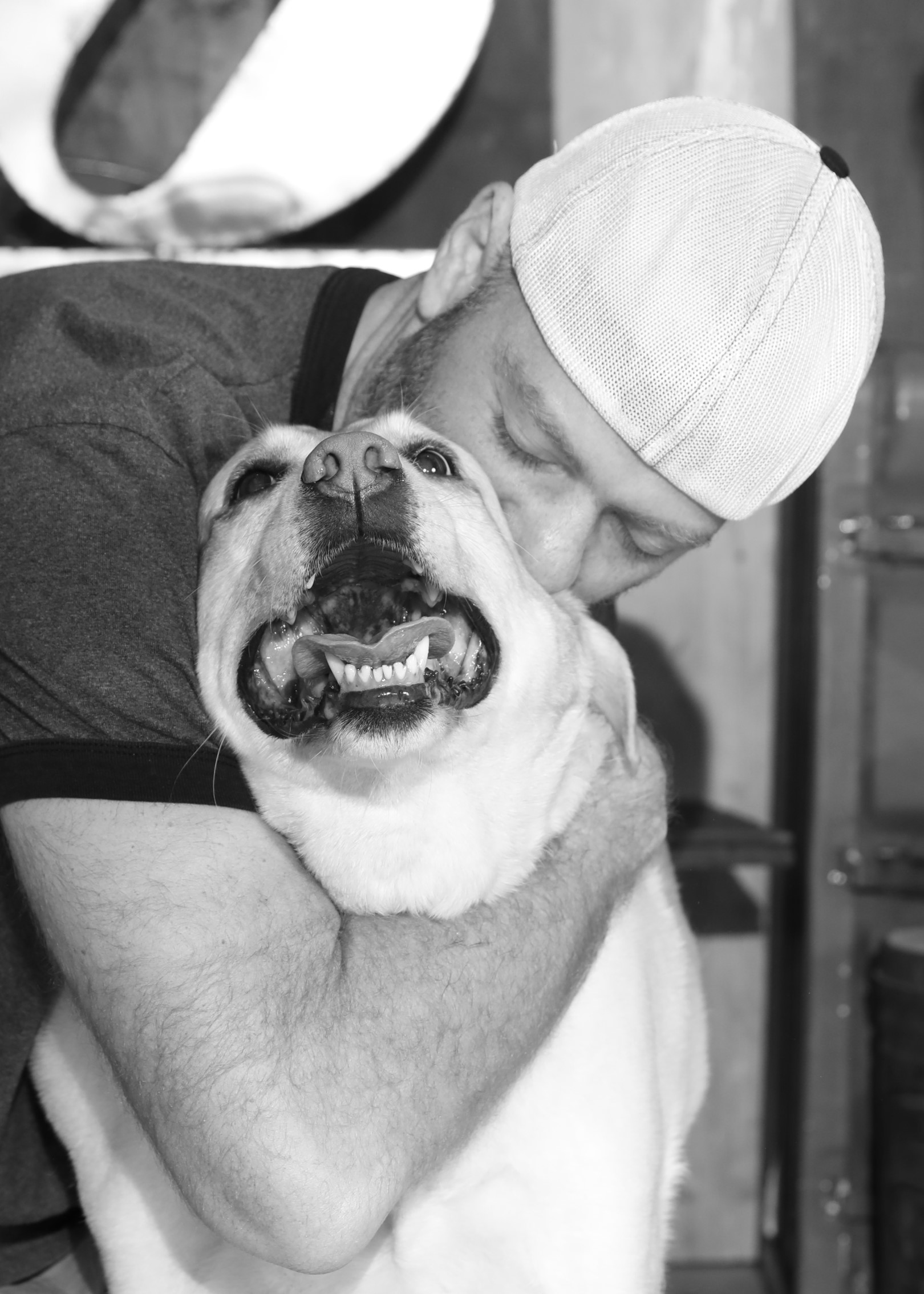Black and White Pet Photography of man hugging kissing dog